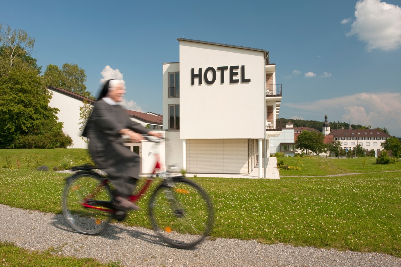 eine Frau fahrradfahrend vor dem Hotel Hegne