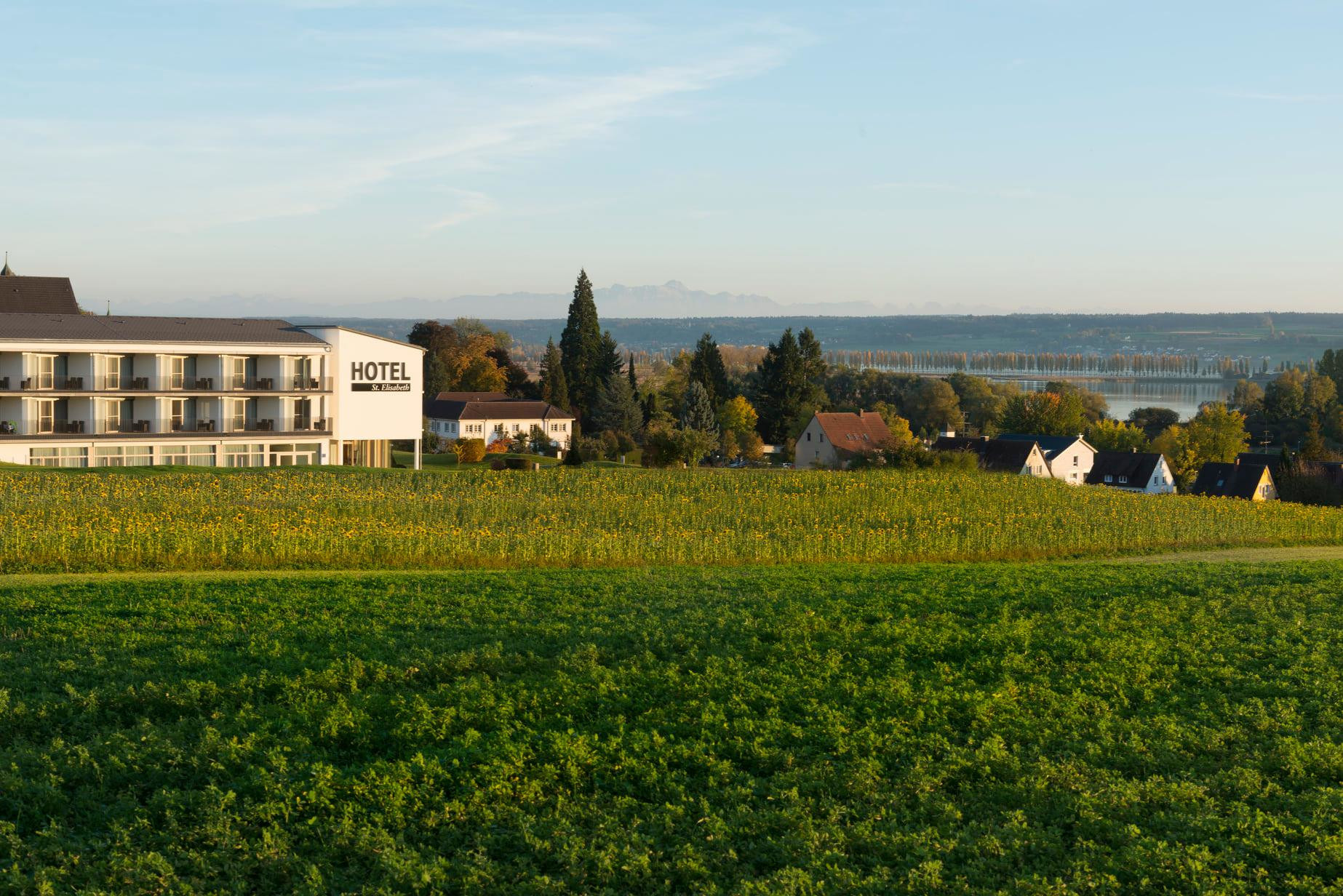 Klosterhotel St.&nbsp;Elisabeth mit einem grünen Feld im Vordergrund