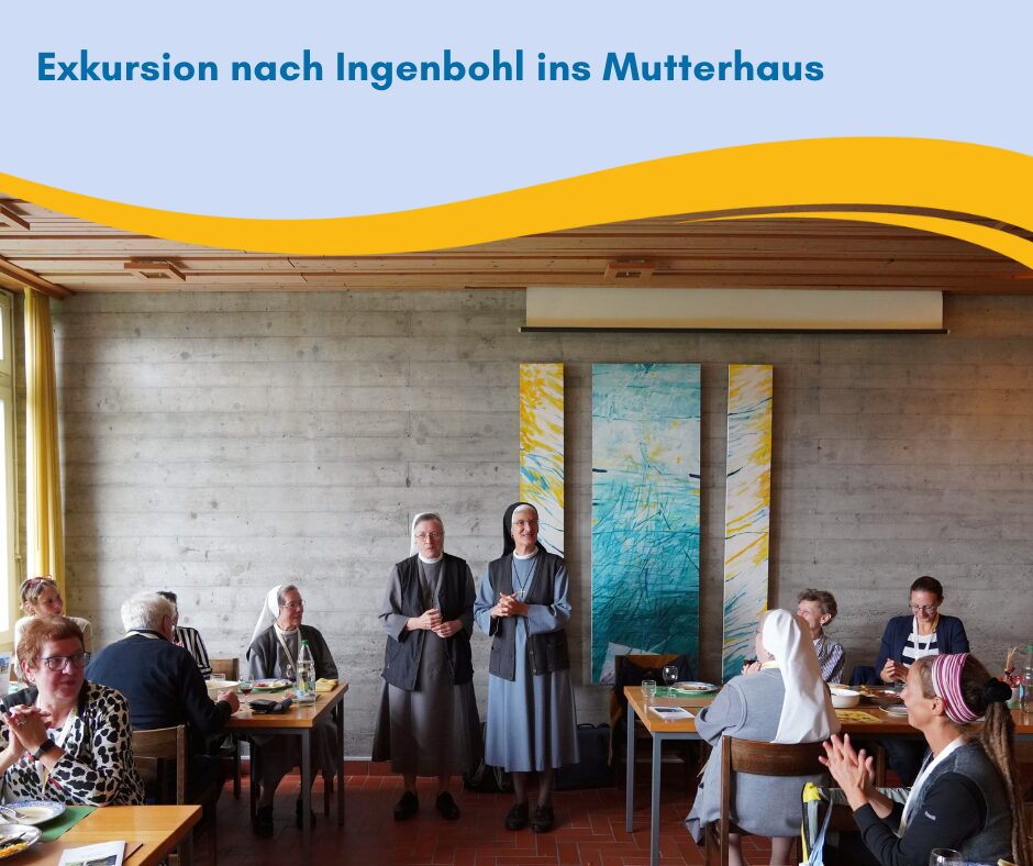 Zwei Frauen begrüßen die angekommenen, die an Tischen platz genommen haben.