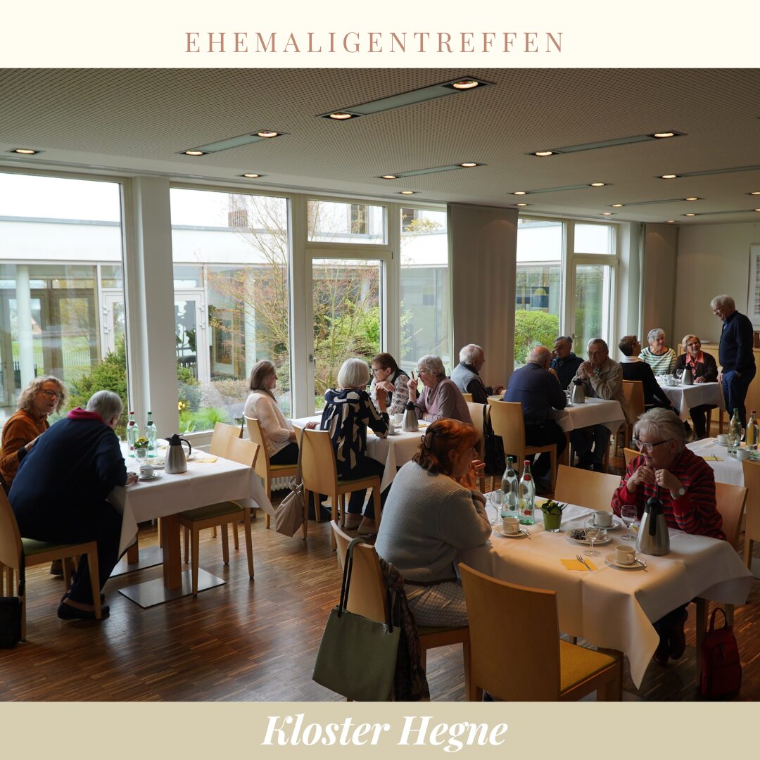 Ein Speiseraum, der mit kleinen Tischen an den Menschen sitzen bestückt ist.