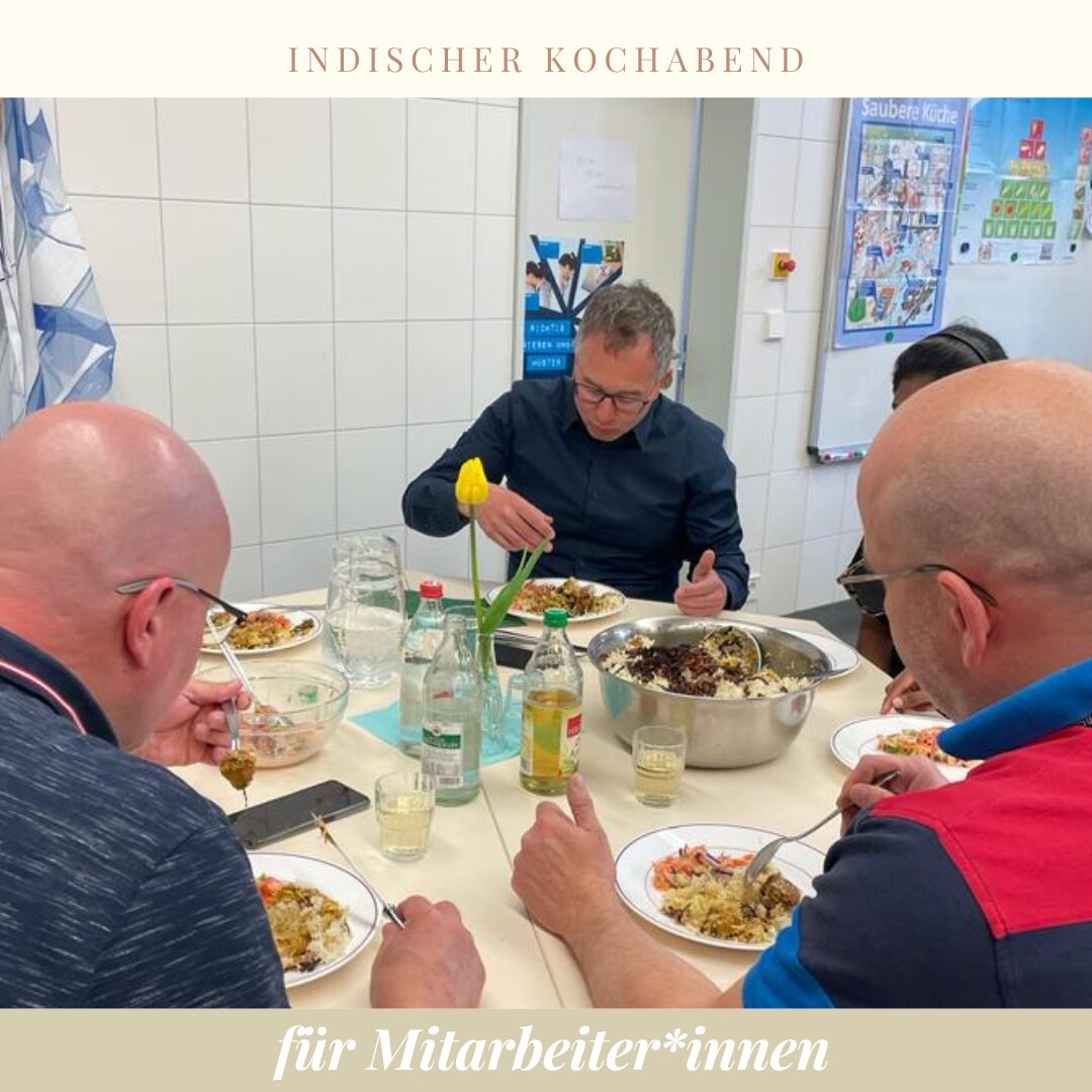 an einem runden Tisch, mit weißer Tischdecke, Getränken und Essen gedeckt, wird gegessen