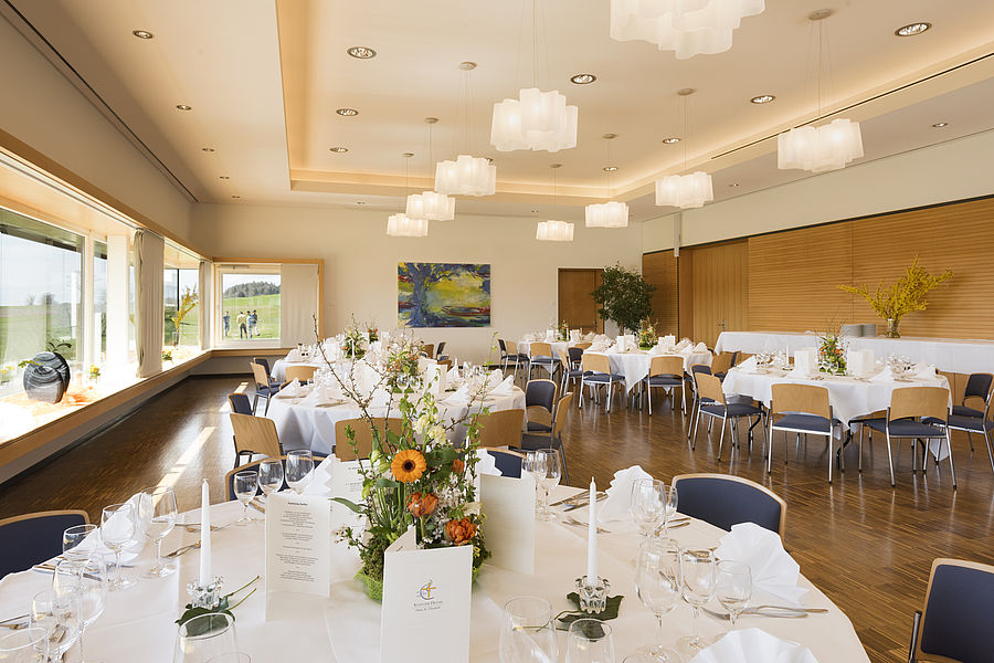 gedeckter und mit Blumensträußen geschmückter Tisch